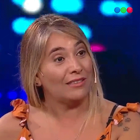 a woman with blonde hair and a tattoo on her arm is smiling .