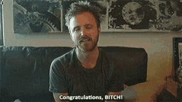 a man with a beard is sitting on a couch and saying congratulations , bitch !
