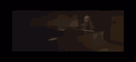 a man is playing a piano in a dark room