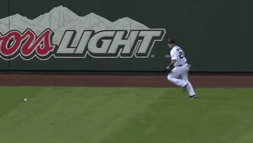 a baseball player with the number 2 on his jersey runs to catch a ball