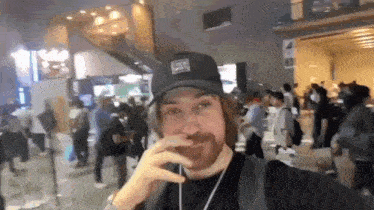 a man with a beard wearing a black hat with the letter l on it .