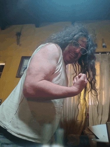 a man with long curly hair wearing sunglasses and a tank top