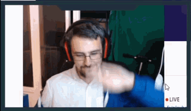 a man wearing headphones and glasses is giving a fist bump