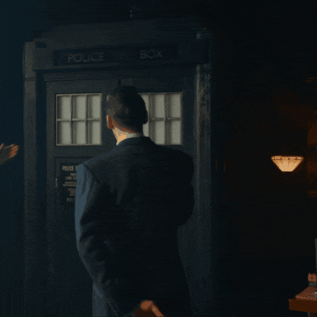 a man is standing in front of a police box
