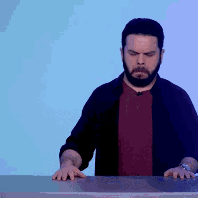 a man with a beard is standing at a table