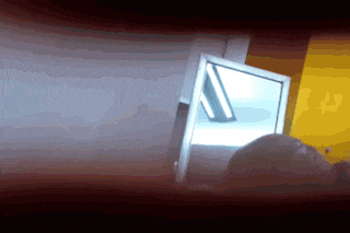a blurred image of a person looking in a mirror with a yellow background