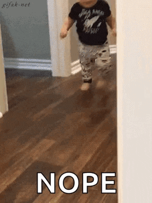 a baby is walking on a wooden floor and the word nope is written on the floor .