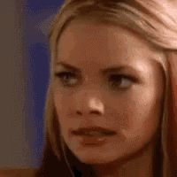 a close up of a woman 's face with a surprised expression on her face .
