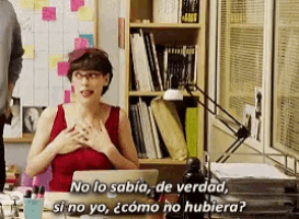 a woman in a red dress is sitting at a desk with a laptop and says no lo sabia de verdad si no yo