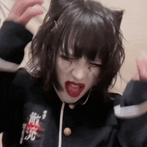 a girl with a cat ear on her head is making a funny face with her mouth open .