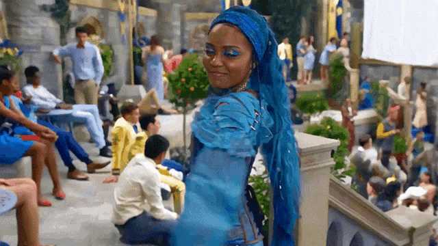 a woman in a blue dress is smiling in front of a crowd