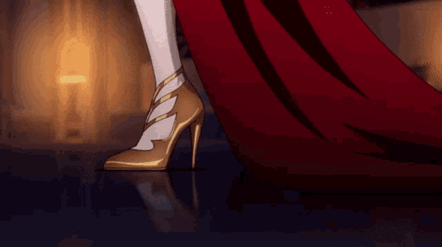 a woman wearing a red dress and gold heels