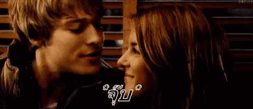 a man and a woman are kissing with a foreign language on the bottom right corner .