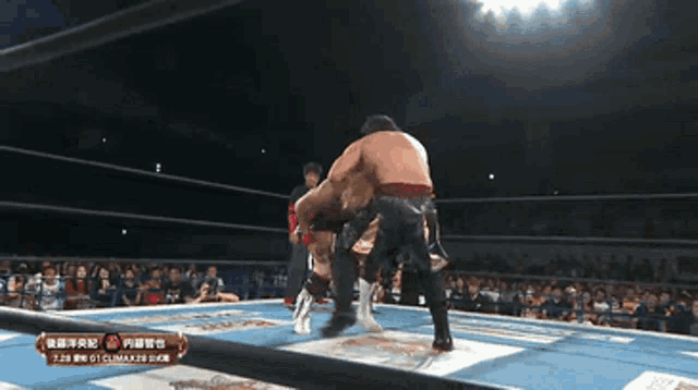 two wrestlers are fighting in a ring with a crowd watching