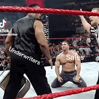 a man is kneeling down in a wrestling ring while another man stands in front of him .