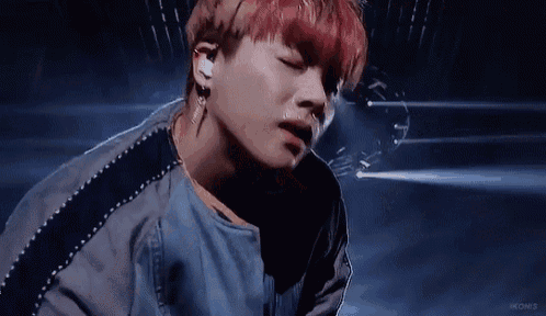 a close up of a person 's face with red hair and earrings .