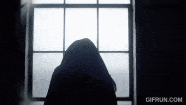 a gif from gifrun.com shows a silhouette of a person looking out of a window