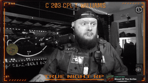a man with a beard stands in front of a microphone with the words true night rp on the bottom right