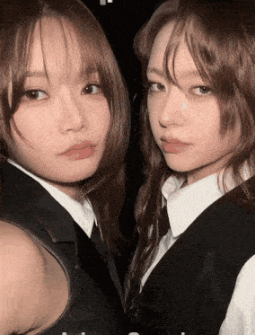 two girls are standing next to each other and one has a tear on her nose