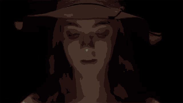 a woman in a witch hat blows out a candle .
