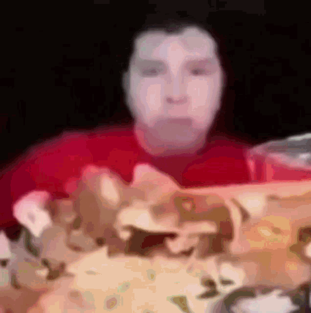a blurry picture of a man sitting at a table with chips in front of him