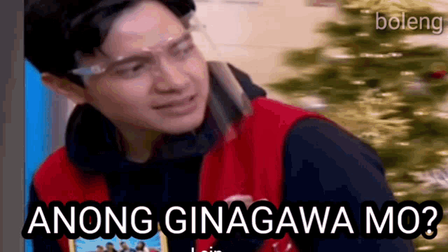 a man wearing a face shield and a red vest says anong ginagawa mo .