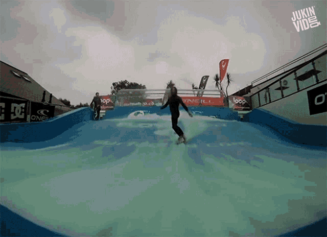 a surfer rides a wave in front of a o'neill banner