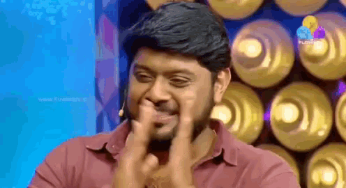 a man with a beard is making a funny face with his fingers .