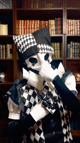 a man in a harlequin costume is covering his face with his hand