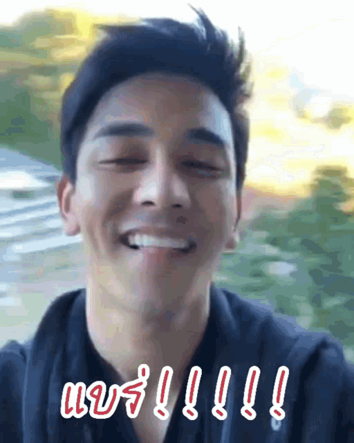 a man in a black shirt is smiling in a blurry photo with a caption that says !!!