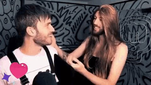 a man with a beard and a woman with long hair are laughing