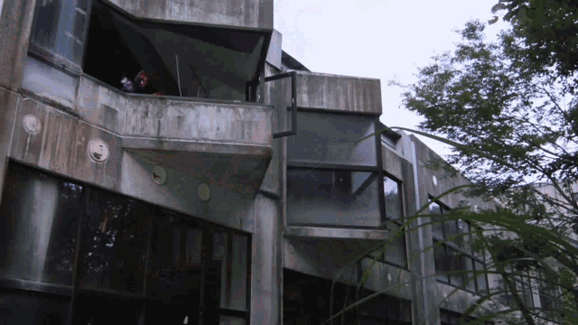 a concrete building with a balcony and a few windows