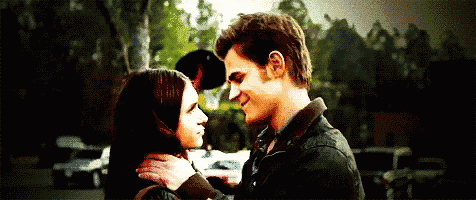 a man and a woman are looking into each others eyes .