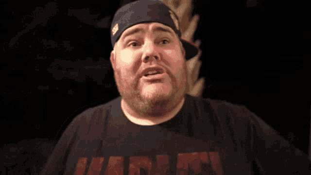 a fat man with a beard is laughing with his eyes closed .