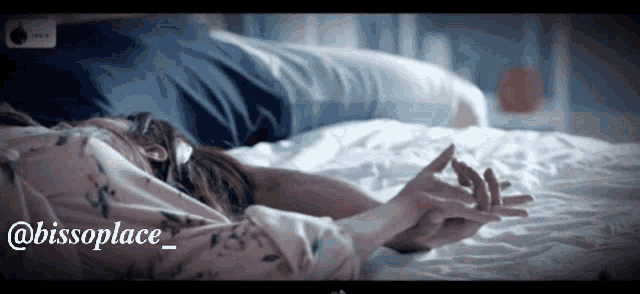a woman laying on a bed holding a man 's hand with the words @bissoplace_ written below her