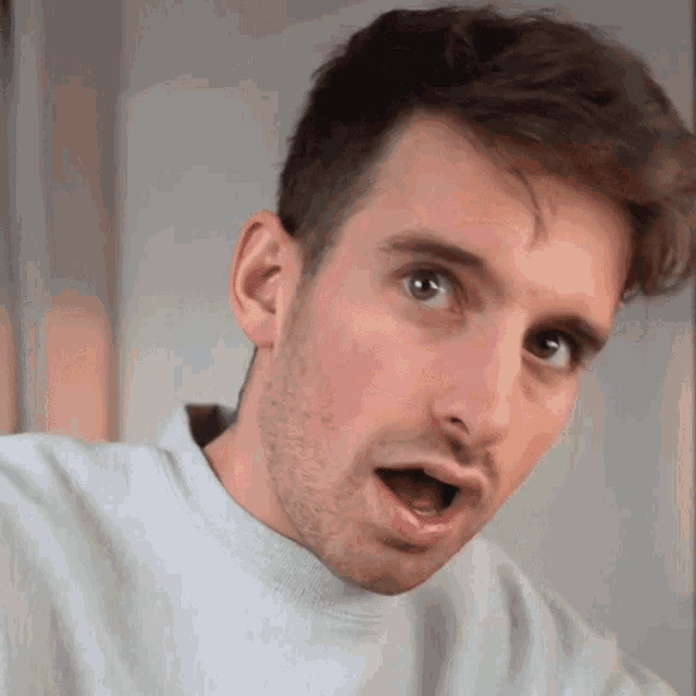 a close up of a man 's face with a surprised look on his face