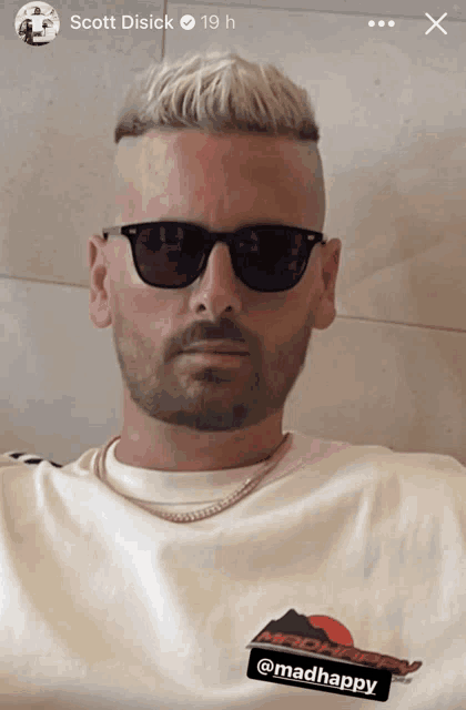 a man wearing sunglasses and a t-shirt with the word madhappy on it