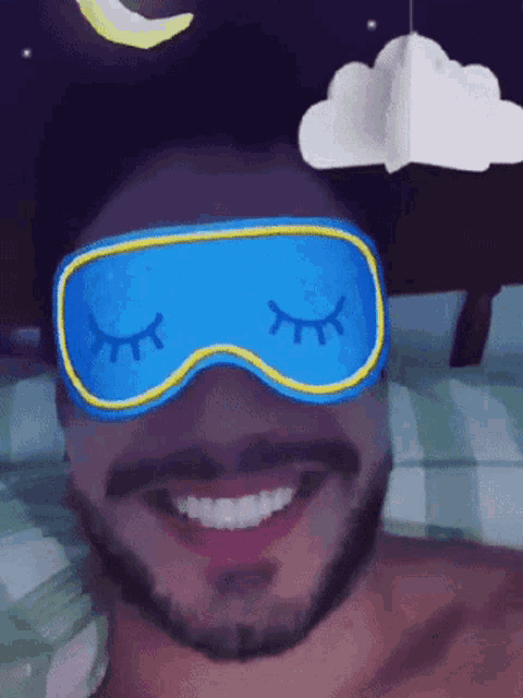 a man wearing a sleep mask with his eyes closed is smiling