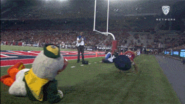 a mascot on a football field with a network logo in the corner