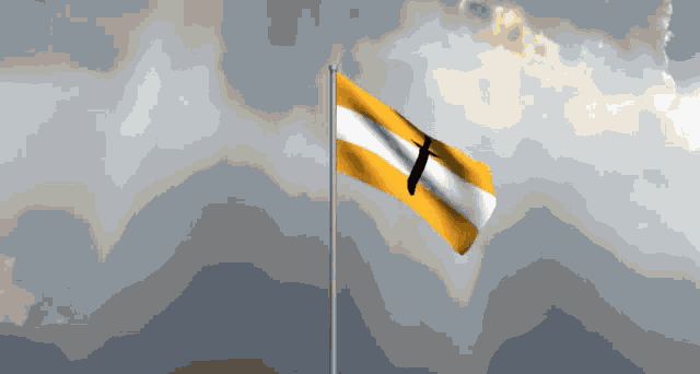 a yellow and white flag with a cross on it is flying in the wind