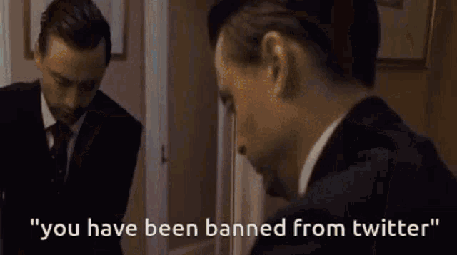 a person is holding a cell phone with the words " you have been banned from twitter " on the screen