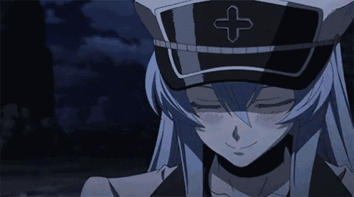 a girl with blue hair is wearing a hat with a cross on it and smiling .