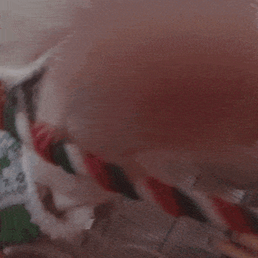 a blurry picture of a person 's face with a green and red sweater on