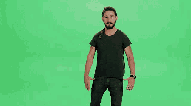 a man in a black shirt is dancing on a green screen and says just do it .