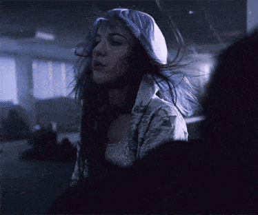 a woman with blue hair is wearing a white hoodie