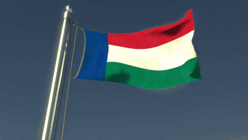 a red white and blue flag is waving in the wind against a blue sky