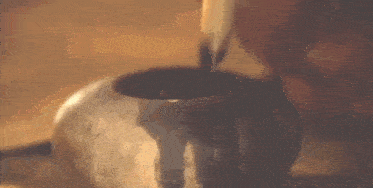 a close up of a person 's hand holding a small metal object .