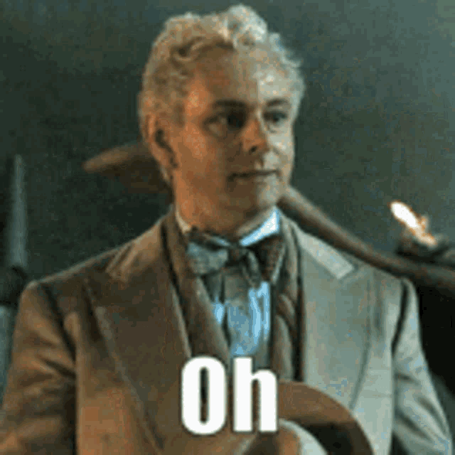 a man in a suit and bow tie is standing in front of a candle and says oh .