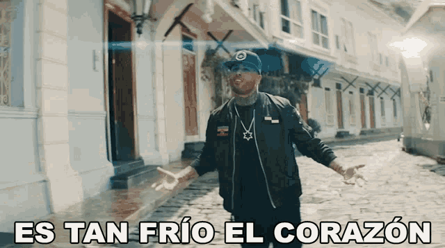 a man standing on a cobblestone street with the words es tan frio el corazon