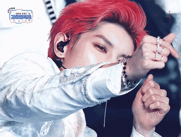 a man with red hair is wearing a white shirt and a bracelet